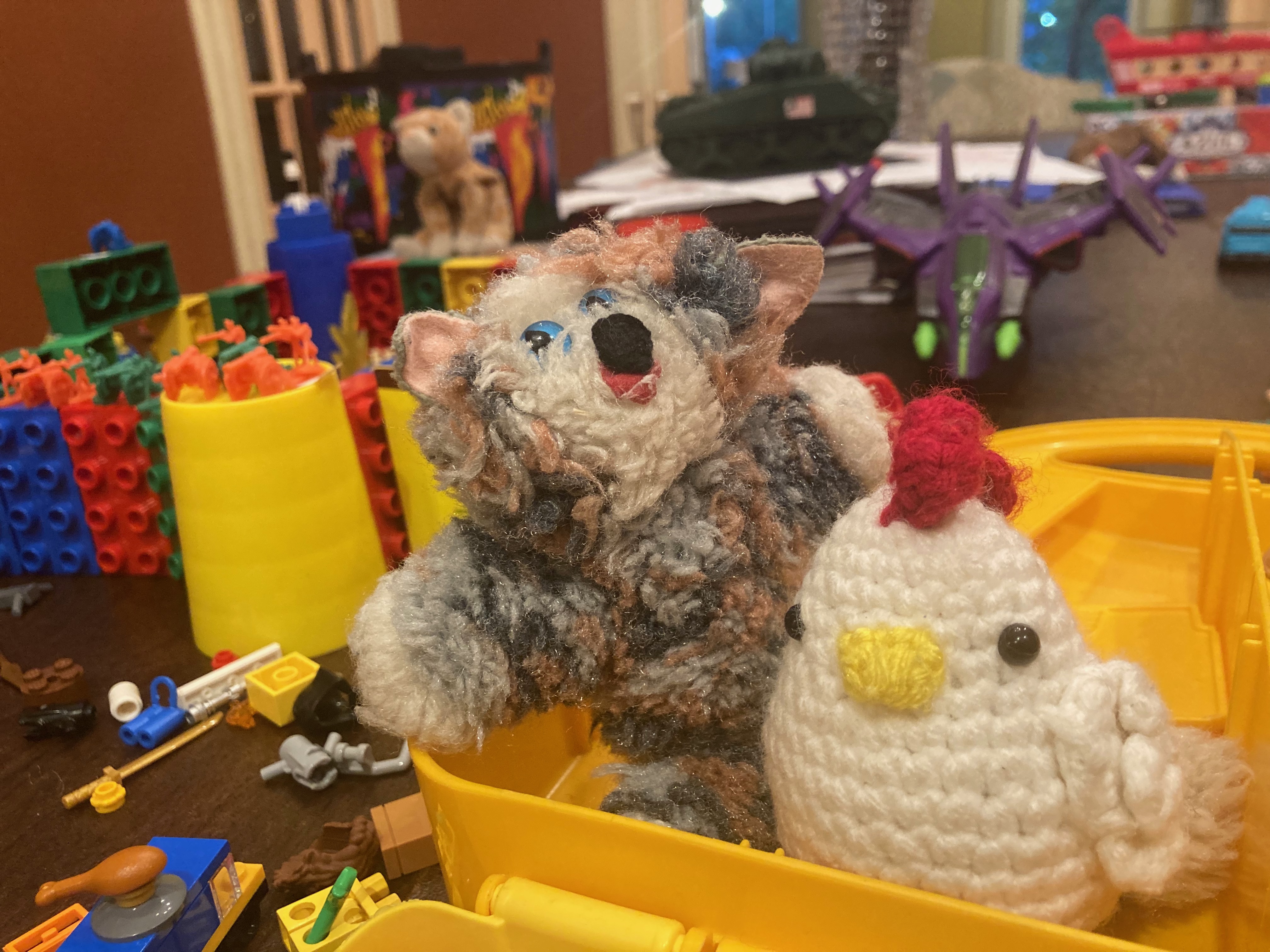 A stuffed animal tiger named Tigger Jack next to a crocheted chicken named Chicken.